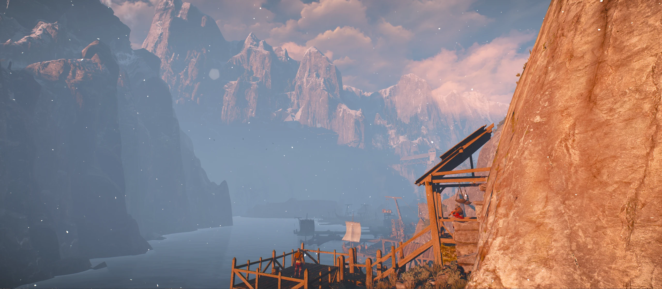 Wooden stairs descend towards sailing boats in the harbour, beneath the mountains of Skellige